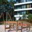 Course playground climbing structure made of wood on sandy ground near residential building