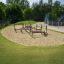 Children's playground with wooden climbing structures in a sandpit.