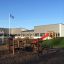 Outdoor play area with Course playground equipment and a red slide.
