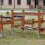 Course wooden playground climbing structure with suspended platforms and rope elements