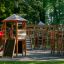 Gigantic castle with slide in a playground surrounded by trees.