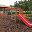 Wooden playground structure with Activity Center with Slide in a park.