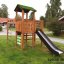 Climbing Kiosk Modern Nature wooden playhouse with slide in a green backyard