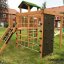 Climbing Kiosk Modern Nature wooden playhouse with slide in a residential backyard