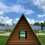 Small House Grass Roof wooden playground structure with green roof in park settings.