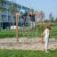 Children climbing and playing on a V-shape Net wooden playhouse in a park.