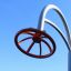 A modern playground climbing structure called Blossom with an orange circular design against a blue 