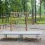 Outdoor playground equipment featuring a Spring Plate with climbing net in a park setting.