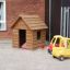 Wooden Nature Playhouse with toy cars in a playground.