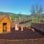 Nature Playhouse in a natural outdoor setting with wooden play structures and wicker fencing.