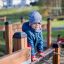 Child playing on Trapezoidal wooden playground.
