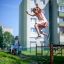 Girl jumping over Trapezoidal playground equipment in a residential area.