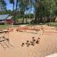Trapezoidal wooden playground structure for outdoor activities.