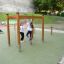 Children playing on Horizontal Ladder wooden ladder in a playground.