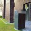 Modern outdoor Oxford bin near a brick building entrance.