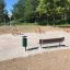 Outdoor HPL Bench in a park setting with exercise equipment.