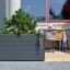 Large grey Sydney Flowerpot with greenery on a patio next to an outdoor cafe table and chairs