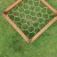 Aerial view of Honeycomb climbing net in wooden frame on grass.