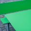 Green Table & Bench HPL set on a stone-paved surface.