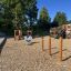 Playground equipment including Somersault Double with slides, climbing walls, and a swing set.