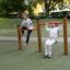 Two kids playing on Somersault Double playground equipment outdoors