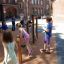 Children playing on Somersault Triple outdoor gym equipment in schoolyard.