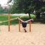 Child hanging upside down on Somersault Triple playground equipment.