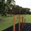 Outdoor fitness equipment, Somersault Triple, in a grassy park area.