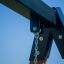 Close-up view of the Single swing chain attachment point against a clear blue sky