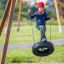 Child playing on a Single swing tire swing outdoors.