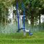 Outdoor Cross Trainer in a green park surrounded by trees and grass.