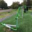 Outdoor Cross Trainer on a grassy fitness area with surrounding trees and a gravel path.