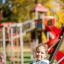 Child using the Safety Seat Single Swing in a playground.