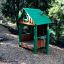 Children's wooden playhouse with green roof by Nill's Playhouse.