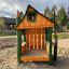 Nill's Playhouse wooden play structure in a sandy outdoor playground