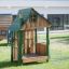 Nill's Playhouse wooden play structure for children on a grassy playground