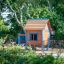 A colorful wooden playhouse named Olle's Playhouse in a park setting.