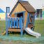 Wooden children's playhouse Olle's Playhouse with a blue ladder and slide.