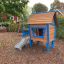Children's wooden playground house with slide, named Olle's Playhouse.