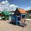 Olle's Playhouse outdoor wooden play structure with slide and sandbox.