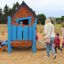 Children playing around the Olle's Playhouse in a park.