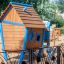 Olle's Playhouse wooden play structure with blue accents on a playground