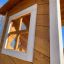 Lisa's Playhouse with slide made of wood with a close-up of a window frame.